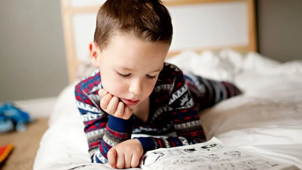 Garçon de 9 ans qui lit une bande dessinée